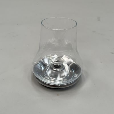 un verre transparent avec un pied en métal posé sur une table