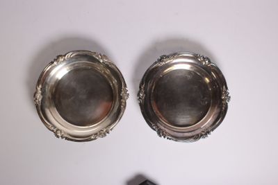 une paire d'assiettes argentées posées sur une table blanche, avec une télécommande