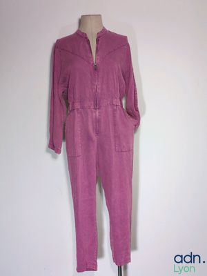purple jumpsuit on a mannequin stand against a white wall