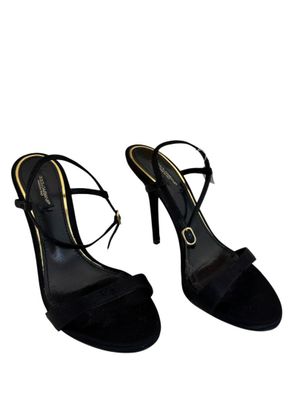 une paire d'escarpins noirs à talons hauts avec une boucle dorée