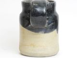 a black and white vase on a white surface