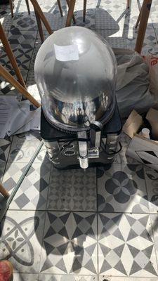 a silver food warmer sitting on the floor next to a table