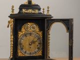 a black and gold clock sitting on a wooden table