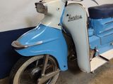 a blue and white motor scooter parked in a garage