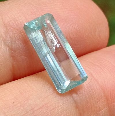 a person holding a very pretty blue stone in their hand