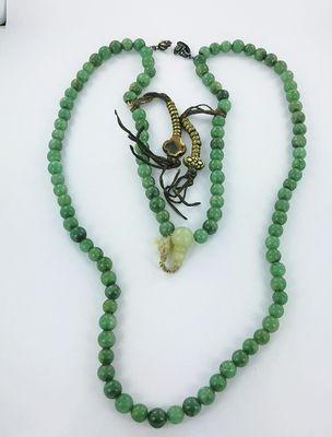 un collier de perles vertes avec un fermoir en forme de serpent et un collier de perles vertes avec un fermoir en forme de serpent