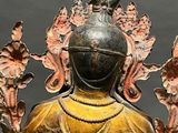 a bronze statue of a person with a bird on his head
