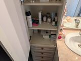 une salle de bains équipée d'un lavabo, d'un miroir et d'étagères