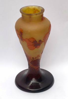 a glass vase with a yellow and red design on it