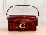 brown leather handbag with gold hardware on a wooden table