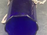 a blue glass vase with a chain around it