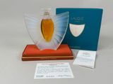 an image of a bottle of perfume sitting on top of a book