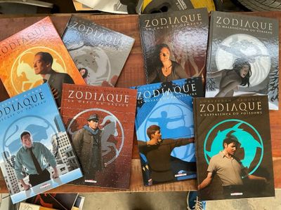 Plusieurs livres sont posés sur une table devant une horloge