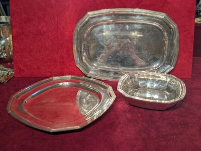trois plateaux en argent posés sur une nappe rouge