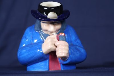 une figurine représentant un homme portant un haut-de-forme et une cravate