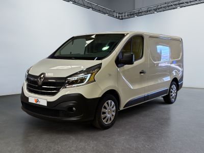 La camionnette blanche est garée à l'intérieur d'une grande pièce blanche.