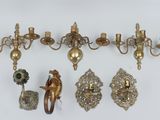 several antique brass wall sconces and a pair of candle holders