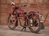 a old red motorcycle that is parked in front of a brick wall