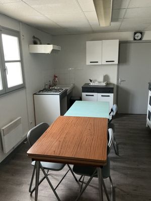 a table and chairs in a kitchen with a clock on the wall