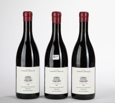 trois bouteilles de vin rouge posées sur une table blanche