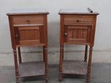 two small wooden tables with marble tops on them