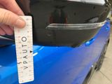 a hand that is holding a piece of paper near a blue car