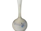 a white vase with blue designs on it on a white surface