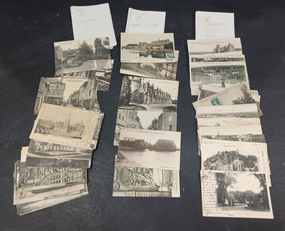 de nombreuses cartes postales anciennes illustrées, posées sur une table