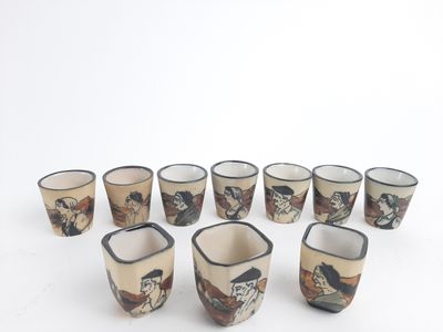 neuf tasses ornées de motifs différents, posées sur un fond blanc