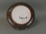 a brown and white plate with a black writing on it