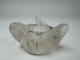 a glass vase with a bird on it on a white surface