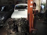 a white car in a garage with other cars in the background