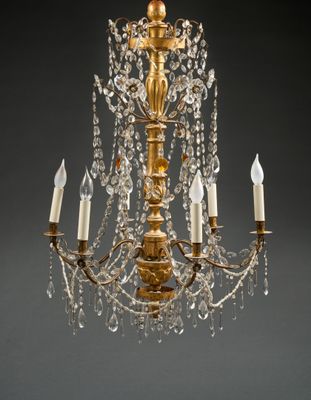 un lustre ancien en laiton orné de pendants en cristal et de bougies