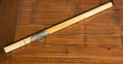 a wooden stick with a metal handle on a wooden floor