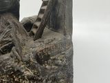 statue of a man laying on a rock with a guitar in his lap