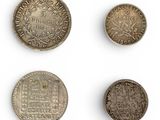 a group of five different coins on a white surface