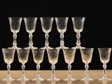 many wine glasses lined up on a wooden table