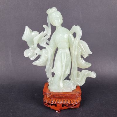 an image of a statue of a woman holding flowers on top of a table