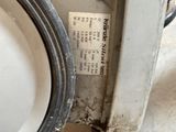 a white toilet sitting on a dirty floor next to a black hose