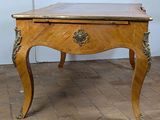 a small wooden table with a marble top on a brick floor
