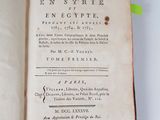 an open book on a white table with a yellow ribbon