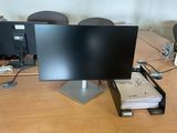 a computer monitor sitting on top of a wooden desk