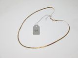 un collier auquel est attachée une étiquette sur une surface blanche