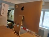an apple computer sitting on a desk in a room