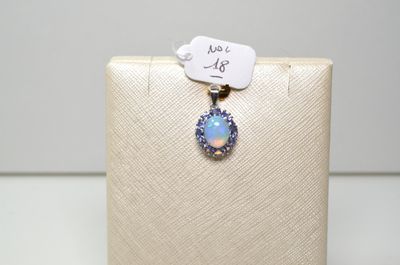 Un pendentif en oplite et diamant est suspendu à un écrin blanc