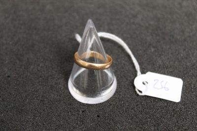 une bague en or posée sur un cône transparent, avec une étiquette de prix