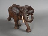 statue of an elephant with tusks and tusks on a gray background