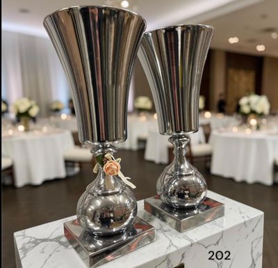 deux vases en argent posés sur une table en marbre