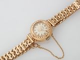 an image of a gold wrist watch with a chain around it