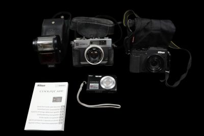three cameras and a bag on a black background